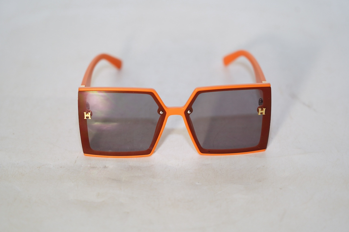 A pair of orange Hermes sunglasses